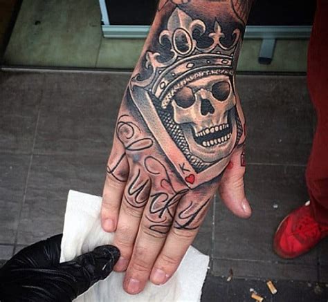 hand skull crown tattoo.